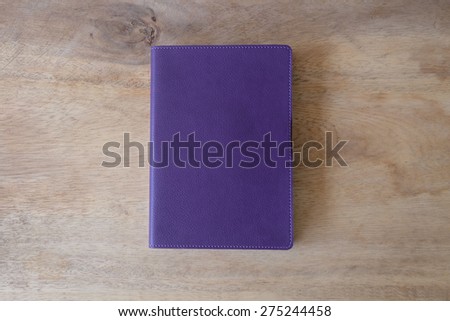 Purple leather notebook on wooden table, the personal organizer