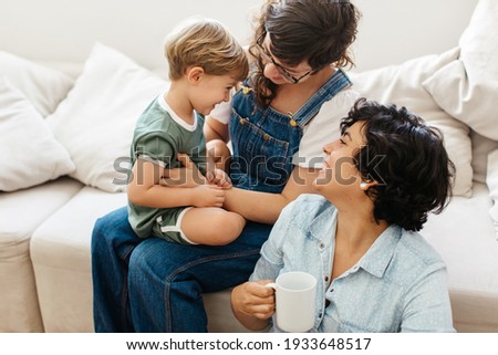 LGBT couple with son at home. Loving lesbian couple playing with their son while spending time together at home.