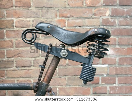 Amsterdam , Netherlands-august 30, 2015: leather bike saddle locked to the frame with a chain