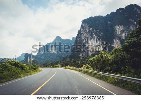 Two-lane road surrounded with mountains and forest in Khao Lak, Thailand
