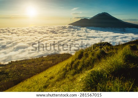 Peaks of volcano above the clouds and sun rising, Indonesia, Bali, Agung