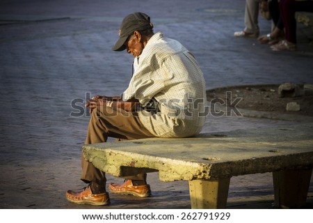 CARTAGENA, COLOMBIA - MARCH 2015: A sad and lonely man sits over a street chair after a hard labor day at the center of the town of Cartagena de Indias
