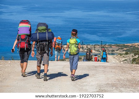 a group of tourists with large backpacks walks along a dirt road overlooking the Mediterranean Sea along the Akamas on the island of Cyprus ストックフォト © 