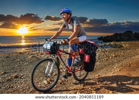 Similar – Image, Stock Photo Man cycling on sandy beach hill