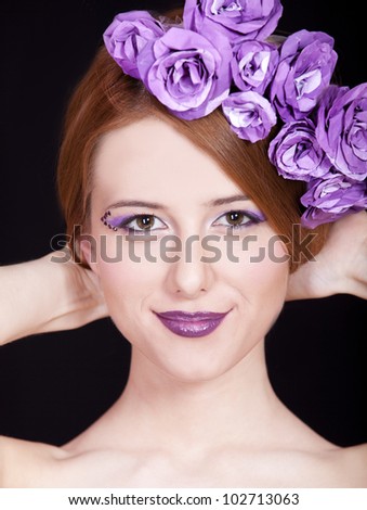 Portrait of beautiful redhead girl with style make-up and flowers.