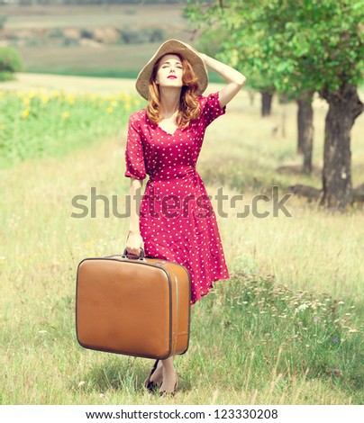 Redhead girl with suitcase at outdoor.