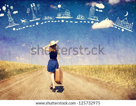 Lonely girl with suitcase at country road dreaming about travel.