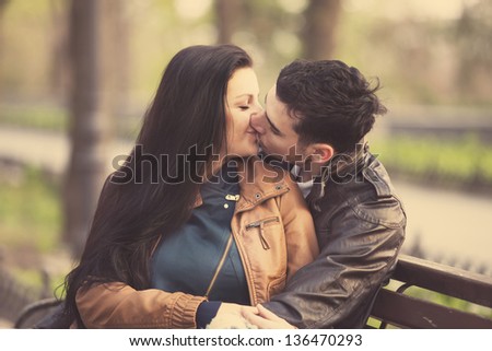 Couple kissing at the bench at alley.