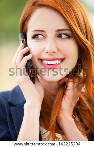 Redhead girl speaking by phone