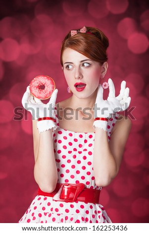 Beautiful redhead women with donut. Photo in retro style with bokeh at background.