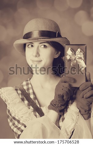 Beautiful women with gift. Photo in retro style with bokeh at background.