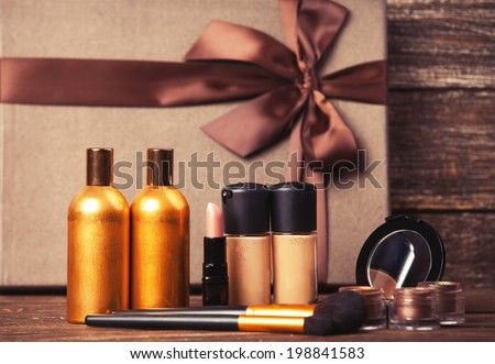 Cosmetics and gift box on wooden table.