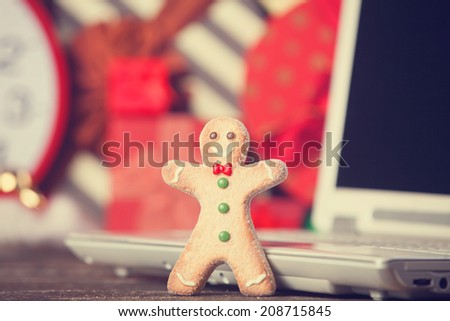 Cookie man and and laptop on christmas background.