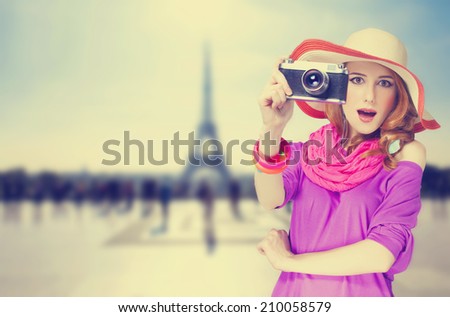 Redhead women with scarf and vintage camera on Parisian background