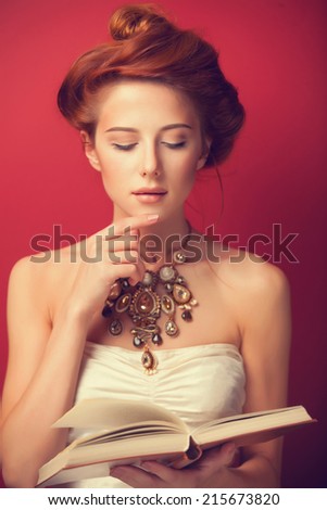 Portrait of redhead edwardian women with book on red background.