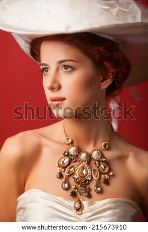 Portrait of redhead edwardian women on red background.