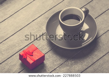Little red gift and cup of the coffee.