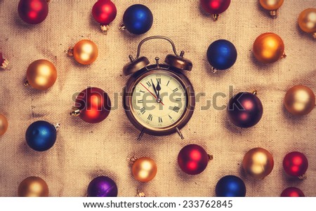 Retro alarm clock with gold, blue and red balls on jute background.