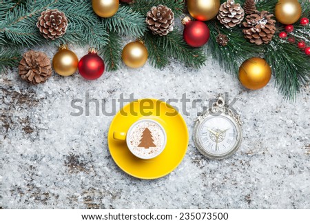 Cappuccino with christmas tree shape and clock on artificial background.