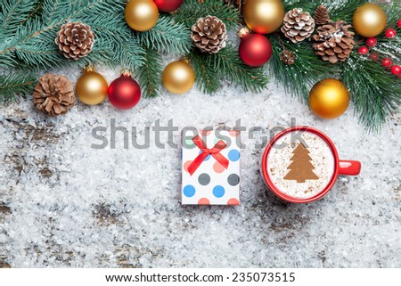 Cappuccino with christmas tree shape and gift box on artificial snow