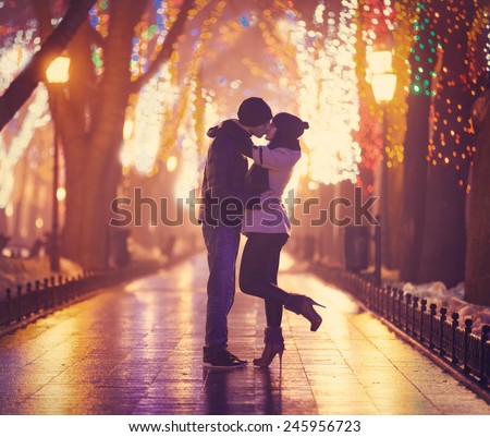Couple kissing at night alley.