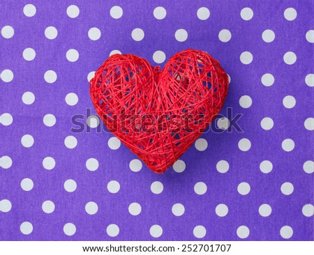 Heart shape decorate toy on polka dot background.