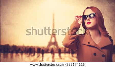 Beautiful redhead women in sunglasses on parisian background.