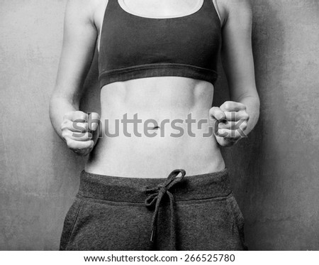 Woman showing her abs after weight loss. Photo in black and white color style.
