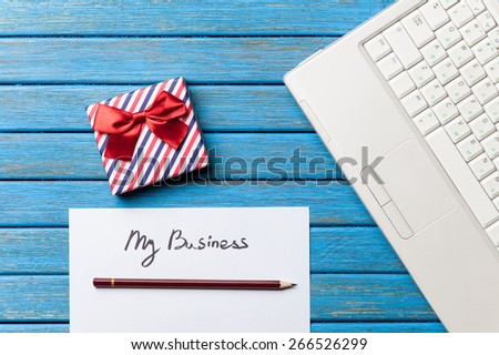 gift and paper with My Business words near notebook on wooden background