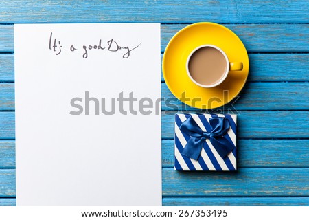 gift and paper with Good day inscription on wooden background