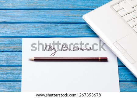 pencil and paper with My Business words near notebook on wooden background