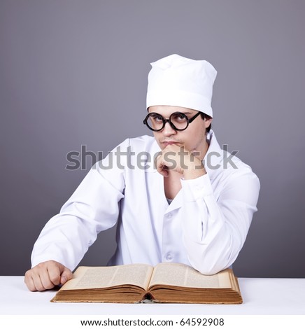 Young male doctor studying medical books. Studio shot.
