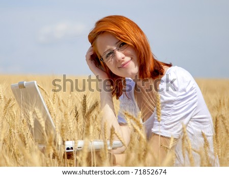 Young Businesswomen in white working with notebook at wheat field.