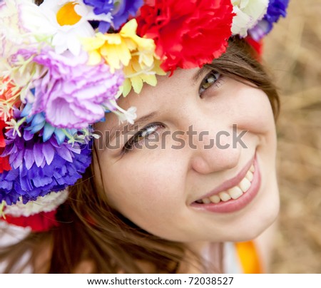 Slav girl with wreath at field