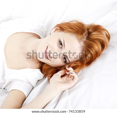 Pretty red-haired sleeping woman in white nightie lying in the bed