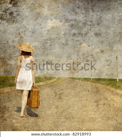 Lonely girl with suitcase at country road.. Photo in old image style.