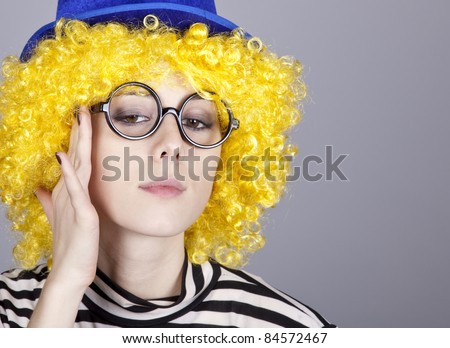 Portrait of yellow-haired girl in blue cap and striped knitted jacket. Studio shot.