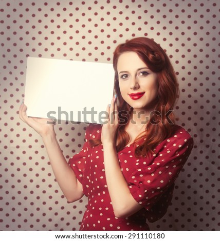 Portrait of a redhead girl with white board on Polka dot background.
