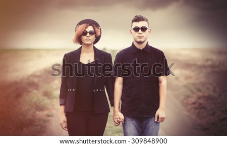 Style young couple at countryside outdoor. Photo in old color image style.