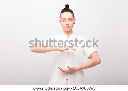 fitness, sport, training and lifestyle concept - Young woman doing yoga exercise. Young Woman praticing tai chi chuan in the gym. Chinese management skill Qi's energy. ストックフォト © 