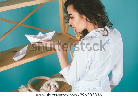 Young business woman holding paper boat with paper boat