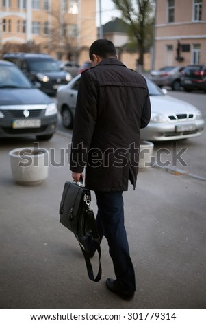 Indian Business man walking down the street with his back to camera