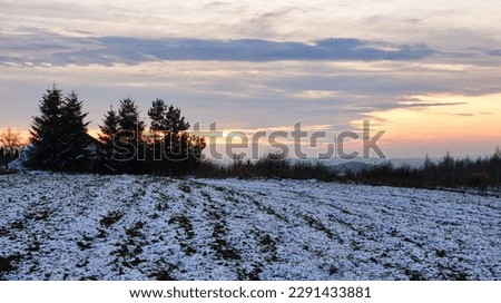Sunrise. Winter view. field covered with snow. In the background, the outline of trees and chimneys of the municipal heat and power plant. beautiful blue sky partially obscured by clouds, Poland Zdjęcia stock © 