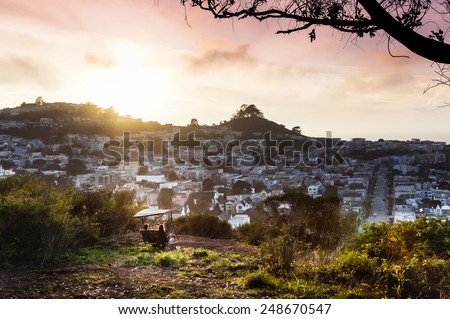A couple enjoying a beautiful sunset at their secret spot in San Francisco, California