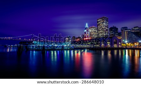 Ferry Building and Bay Bridge illuminated at night in San Francisco, California, USA