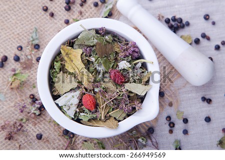 Herbal tea with blackberry, dry mint leaves and briar in the white mortar and with pestle