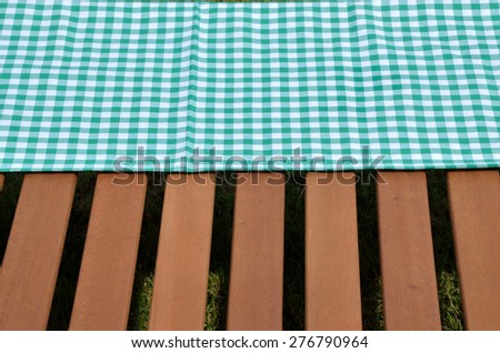 Green and white tablecloth and wooden surface set outdoor