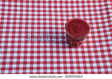 Raspberry smoothie set on red-white tablecloth