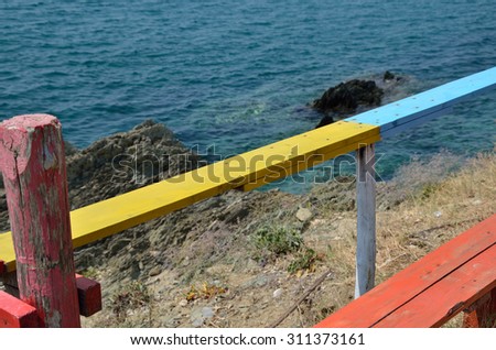 Colorful wooden bar table and bench over sea