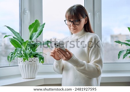 Similar – Image, Stock Photo Serious woman browsing smartphone at home